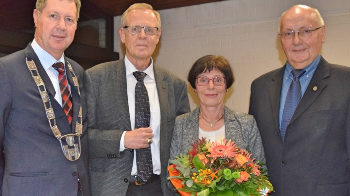 Bürgermeister Peter Wirtz (li.) zeichnet Roman Limbach (2.v.li) mit dem Ehrenring der Stadt Königswinter für langjähriges Engagement aus.
